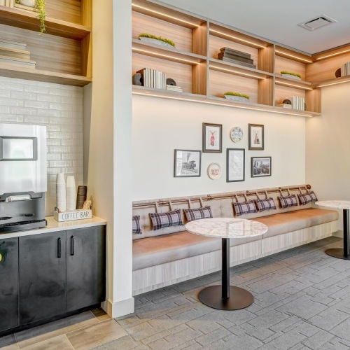 Quick access to state-of-the-art amenities a clubroom with a coffee area and a table